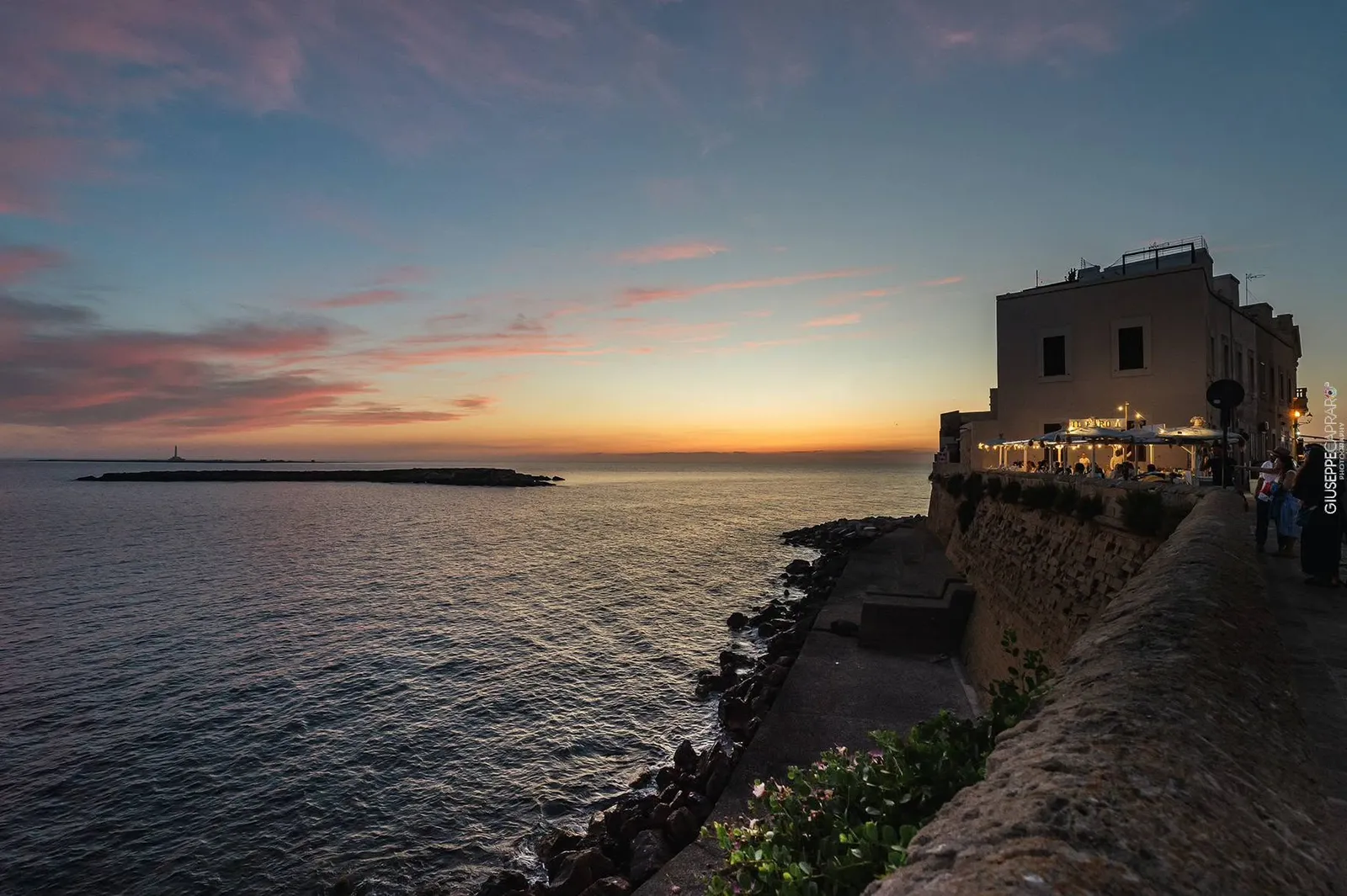 Le mura e il mare nelle ultime luci del giorno.